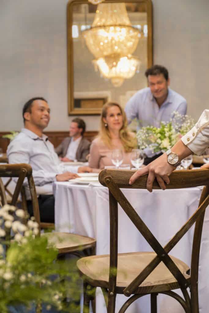 Gezellig restaurant met gasten en ober tijdens diner.